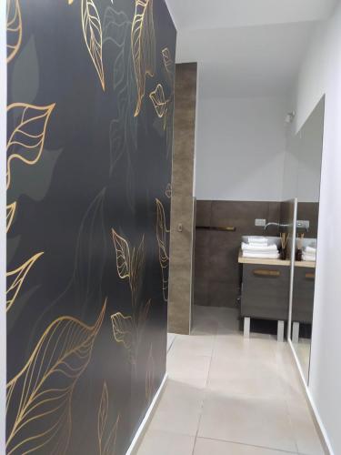 a bathroom with a black and gold wall at Lake 360 Apart Villa Carlos Paz in La Cuesta