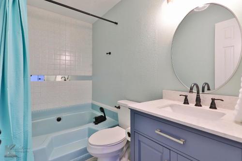 ein Badezimmer mit einem Waschbecken, einem WC und einem Spiegel in der Unterkunft Lazy Boho Resort: Roomy Lux. Home w/ Private Pool in Abilene