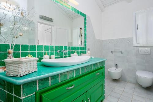 ポルト・チェルボにあるVilla privata con piscina in Pantogiaの緑と白のバスルーム(洗面台、トイレ付)
