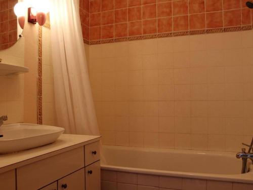 uma casa de banho com um lavatório e uma banheira em Appartement Port-la-Nouvelle, 2 pièces, 4 personnes - FR-1-229C-170 em Port-la-Nouvelle