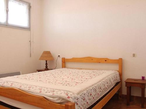 um quarto com uma cama com uma moldura de madeira e uma janela em Appartement Port-la-Nouvelle, 2 pièces, 4 personnes - FR-1-229C-170 em Port-la-Nouvelle