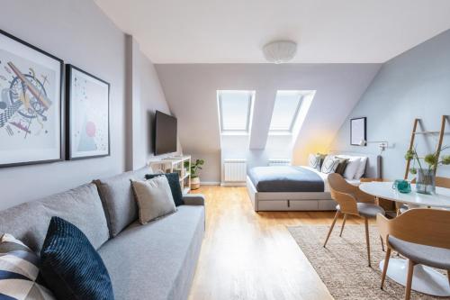 a living room with a couch and a bed at TurnKey I Angelo Roma Apartments in Prague