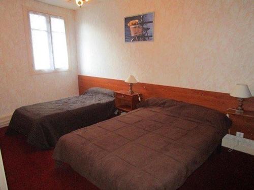 une chambre d'hôtel avec deux lits et une fenêtre dans l'établissement Appartement cosy 4 pers à 50m des thermes et 300m des pistes, wifi, ascenseur - FR-1-234-128, à Cauterets