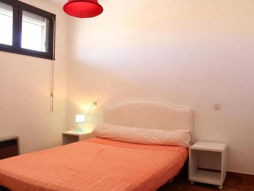 um quarto com uma cama e um candeeiro vermelho em Appartement Port-la-Nouvelle, 2 pièces, 4 personnes - FR-1-229C-20 em Port-la-Nouvelle