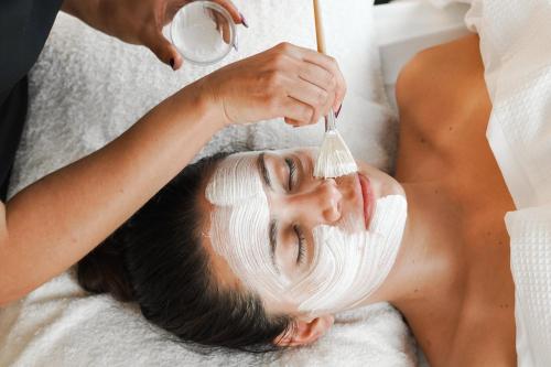 a woman with a mask on her face with a toothbrush at InterContinental Melbourne The Rialto by IHG in Melbourne