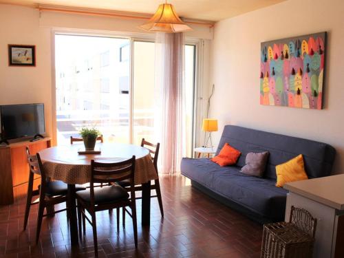 un salon avec un canapé bleu et une table dans l'établissement Appartement 3 pièces, 6 couchages, proche plage et centre, balcon, classé 2 étoiles, ménage inclus - FR-1-229C-608, à Port-la-Nouvelle