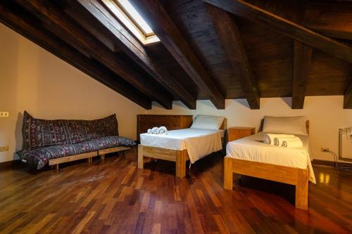 uma sala de estar com duas camas e um sofá em Griffoni Home, in the Heart of the City em Bolonha