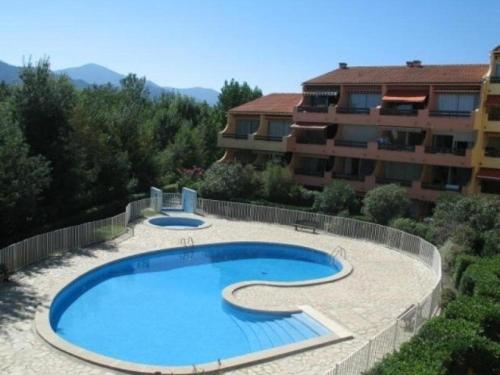 une grande piscine devant un immeuble dans l'établissement Appartement T2 avec piscine, parking privé, proche plage - 4 couchages - Argelès-sur-Mer - FR-1-388-8, à Argelès-sur-Mer