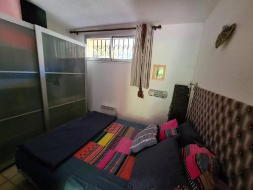 - une chambre avec un lit et une couverture colorée dans l'établissement Appartement T2 avec terrasse, jardinet, piscine et parking privé - Argelès-sur-Mer - FR-1-388-57, à Argelès-sur-Mer