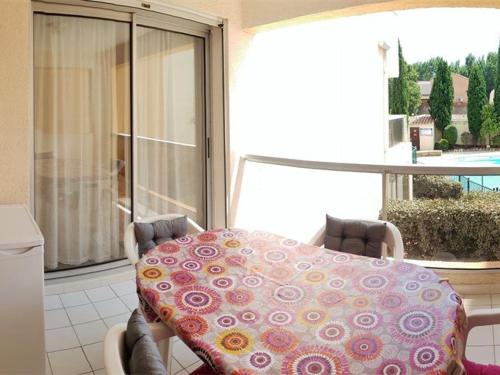 - une table avec une couverture sur le balcon dans l'établissement Charmant T2 avec Piscine et Parking Privé, Proche Plage et Centre, Argelès-sur-Mer - FR-1-388-88, à Argelès-sur-Mer