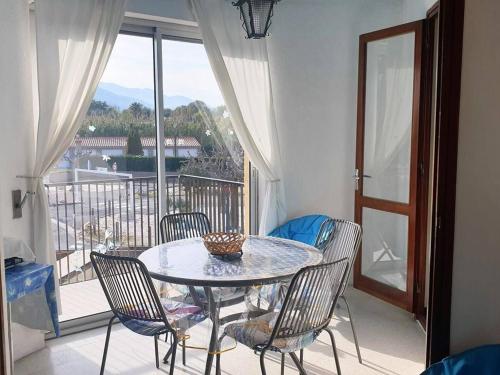 d'une table et de chaises sur un balcon avec une table et une fenêtre. dans l'établissement Studio Cabine Climatisé pour 4, à 100m de la Plage, Argelès-sur-Mer - FR-1-388-104, à Argelès-sur-Mer