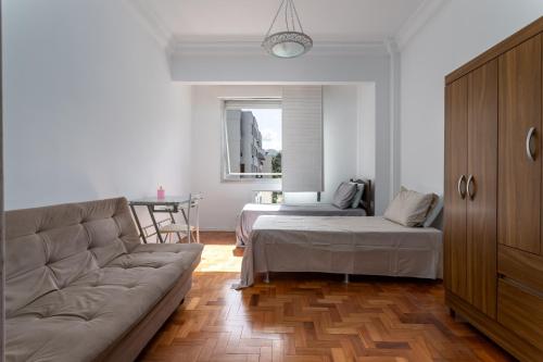 sala de estar con sofá y cama en Simple Style Leme, en Río de Janeiro