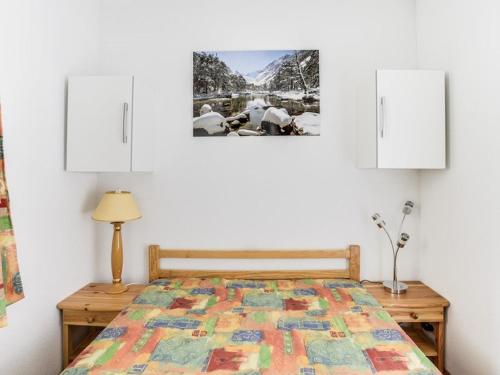 une chambre avec un lit avec une couette dessus dans l'établissement Appartement cosy à Cauterets, 4 pers, balcon, proche centre et télécabine - FR-1-401-111, à Cauterets