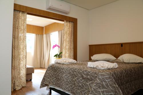 Un dormitorio con una cama grande y una ventana en Solar das Águas - HOTEL, en Marcelino Ramos
