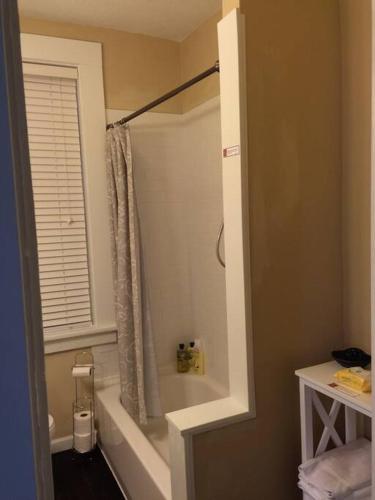 een badkamer met een bad en een douche met een raam bij Your home away from home! First floor LTR discounts 533 in Pittsburgh