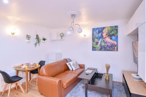 un salon avec un canapé et une table dans l'établissement Paris La Villette - Charming Apartment 2 rooms, à Paris