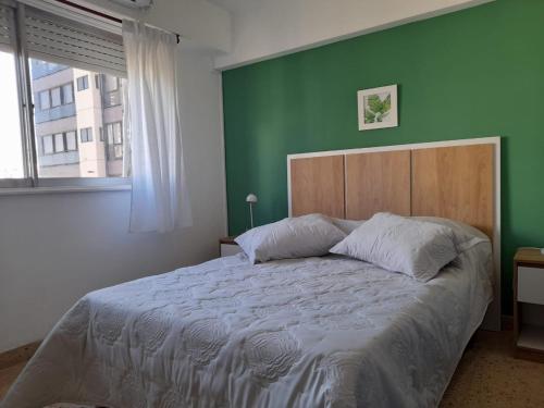 1 dormitorio con 1 cama grande y pared verde en Departamento reciclado a nuevo a 3 cuadras del mar en Mar del Plata