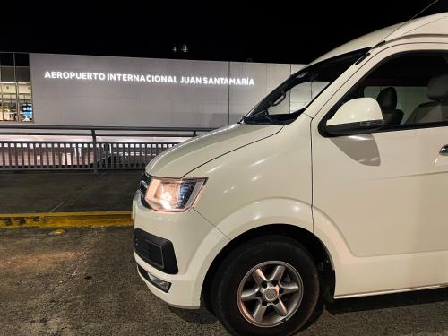 una furgoneta blanca estacionada en un estacionamiento en Casa Garitas GuestHouse - Free SJO Airport Shuttle en Santiago Este