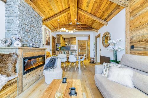 a living room with a couch and a fireplace at Appartement style chalet 5* vue Mont-Blanc - Arc 1950 in Arc 1950
