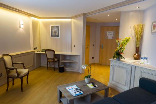 a living room with a couch and a table at Cottage Logis Hôtel - Restaurant in Dudelange