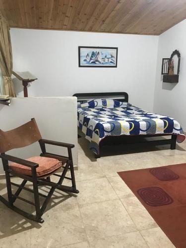 ein Schlafzimmer mit einem Bett, einem Stuhl und einem Stuhl in der Unterkunft La Isabela in Pitalito