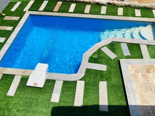 a swimming pool in a yard with green grass at Dahab Hills Villa and Studios in Dahab