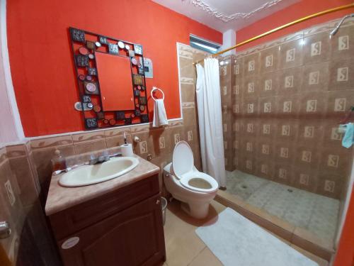 uma casa de banho com um WC, um lavatório e um espelho. em Casa de Alondras em Panajachel