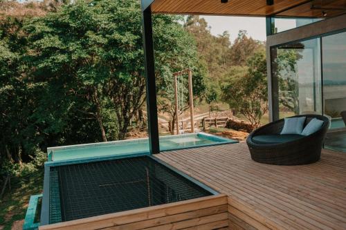 a deck with a plunge pool and a chair on it at Casas na montanha - Villa Montegrappa in Caxias do Sul