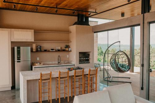 a kitchen with a table and chairs and a large window at Casas na montanha - Villa Montegrappa in Caxias do Sul
