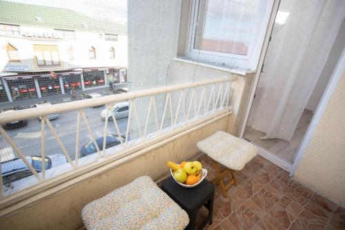 a bowl of fruit on a table next to a balcony at Apartman Mirna Vinkovci in Vinkovci