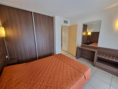 une chambre avec un lit et un grand miroir dans l'établissement Appartement T2 climatisé avec terrasse, proche plage à Argelès-sur-Mer, parking et piscine inclus - FR-1-388-202, à Argelès-sur-Mer