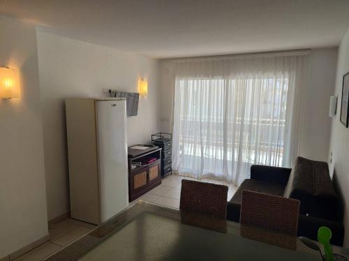 - un salon avec un réfrigérateur et un canapé dans l'établissement Appartement T2 Climatisé, Terrasse de 23m², Piscine, Parking, à 100m de la Plage, Argelès-sur-Mer - FR-1-388-203, à Argelès-sur-Mer