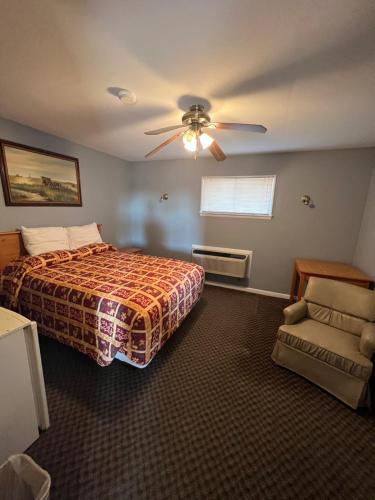 Western Motel في Sayre: غرفة نوم بسرير ومروحة سقف