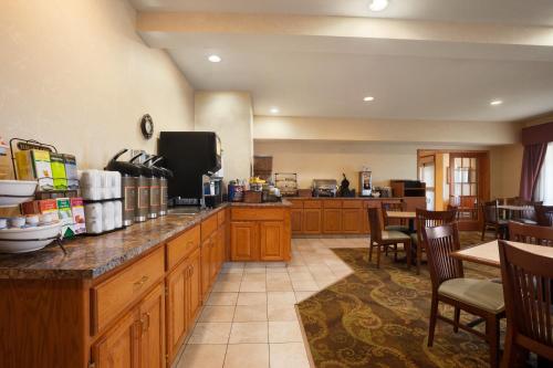 a large kitchen with wooden cabinets and a counter top at Country Inn & Suites by Radisson, Albert Lea - Austin in Albert Lea