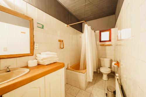 uma casa de banho com um lavatório, um WC e uma banheira em Espacio Ecole Pucon em Pucón