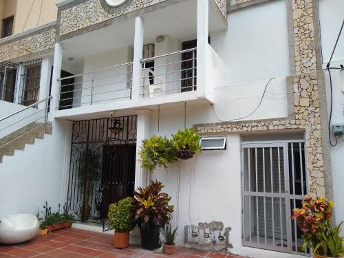 a white house with a door and a balcony at La Habitación Perfecta in Barranquilla