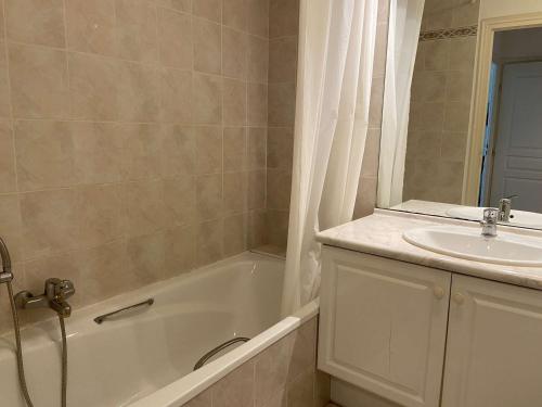 une salle de bain avec une baignoire et un lavabo dans l'établissement Appartement 2P calme avec piscine, terrasse et parking - Fréjus - FR-1-226A-78, à Fréjus