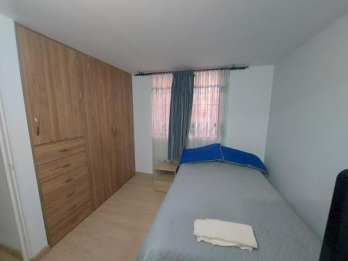 um pequeno quarto com uma cama e uma janela em Apartamento Luna 170 em Bogotá