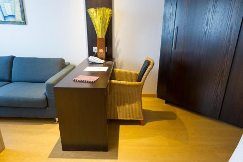 a living room with a table and a couch at Cottage Logis Hôtel - Restaurant in Dudelange