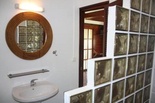 La salle de bains est pourvue d'un lavabo et d'un miroir. dans l'établissement Raiatea Airport Bungalow, à Uturoa