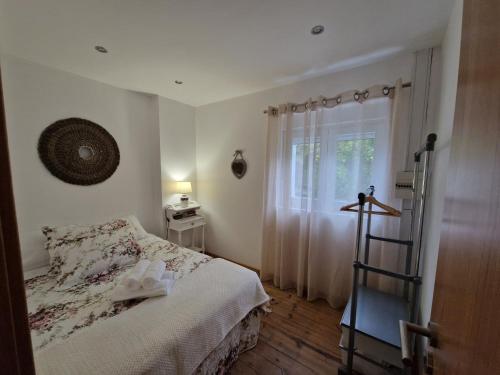 um pequeno quarto com uma cama e uma janela em Moradia T2 em bairro pitoresco da Covilhã na Covilhã