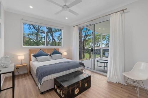 a bedroom with a bed and a large window at The Quarterdeck in Callala Bay