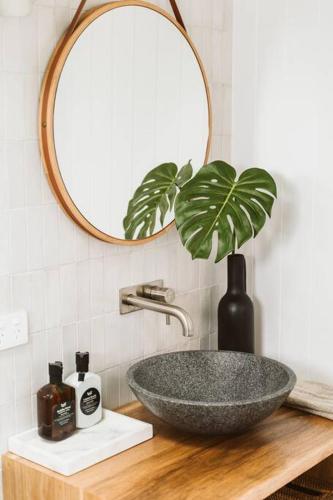 a bathroom sink with a mirror and a plant at The Lull Culburra in Culburra Beach