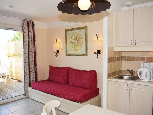 - un banc rouge dans la cuisine avec évier dans l'établissement Maison duplex cosy 3 pièces, 6 pers. avec terrasse, parking, WIFI et animaux admis - Grospierres - FR-1-382-13, à Grospierres