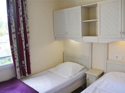 - une petite chambre avec 2 lits et des placards blancs dans l'établissement Maison duplex cosy 3 pièces, 6 pers. avec terrasse, parking, WIFI et animaux admis - Grospierres - FR-1-382-13, à Grospierres