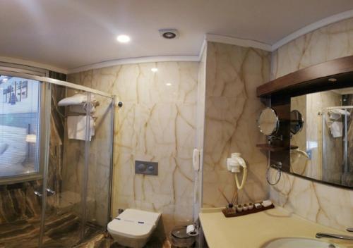 uma casa de banho com um chuveiro, um WC e um lavatório. em Şelale Otel em Rize