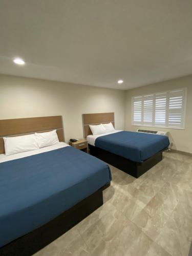 a bedroom with two beds and a window at Super 8 by Wyndham Bakersfield CA in Bakersfield