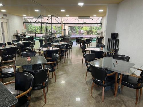 un comedor lleno de mesas y sillas en Brasao Palace Hotel en Presidente Prudente