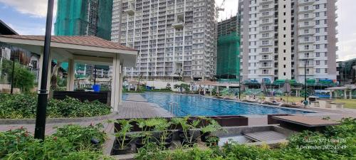a swimming pool in a city with tall buildings at A cozy 2 bedroom condo in Metro in Manila