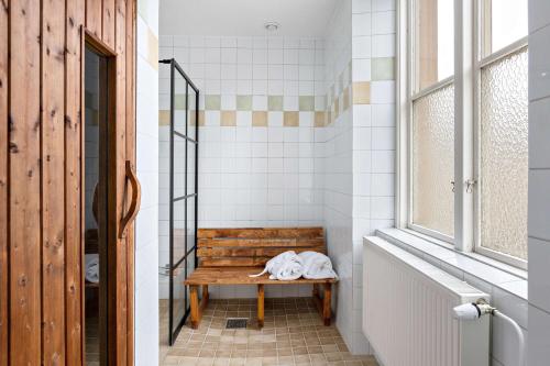 un banco de madera en un baño con ventana en Nora Stadshotell, Sure Hotel Collection by Best Western en Nora